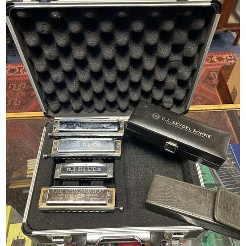 212 - A group of four harmonicas, comprising a Hohner Chrominica in G, a C A Schone in C, another and a Di... 