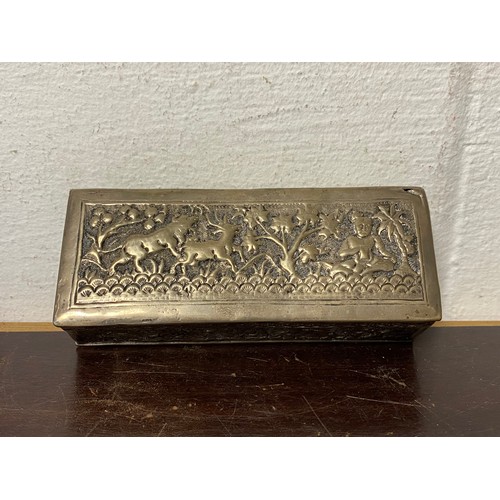 9 - An Eastern white metal box, decorated with figures and animals -