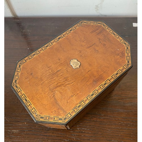 91 - A 19th century inlaid tea caddy, with canted corners, applied with crested plaque -