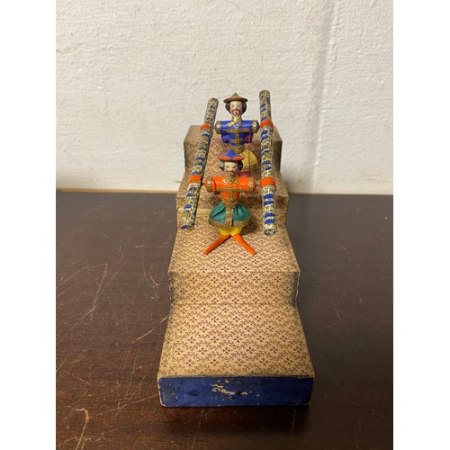 98 - A 19th Century acrobatic tumbling toy, featuring two carved and painted Chinese figures on a stepped... 