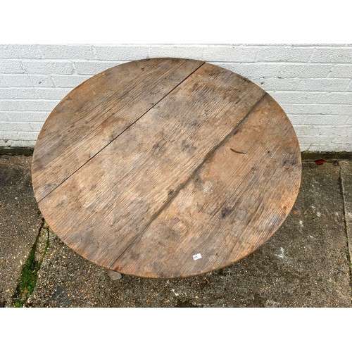 387 - A 19th Century pine cricket table, with circular top over triangular undertier -