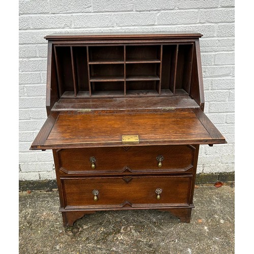 391 - A carved oak bureau the fall front carved with beasts, over three graduated drawers and bracket feet... 