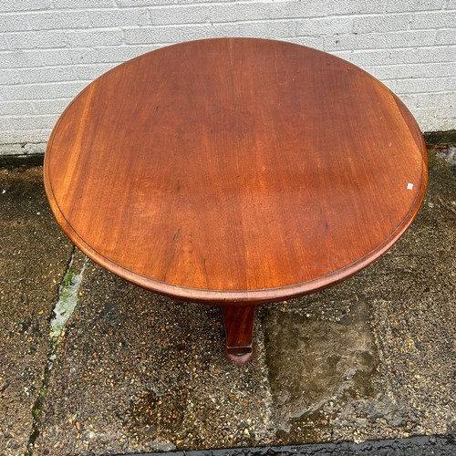 397 - A Victorian mahogony dining table, the circular tilt top on centre pillar and triform base -