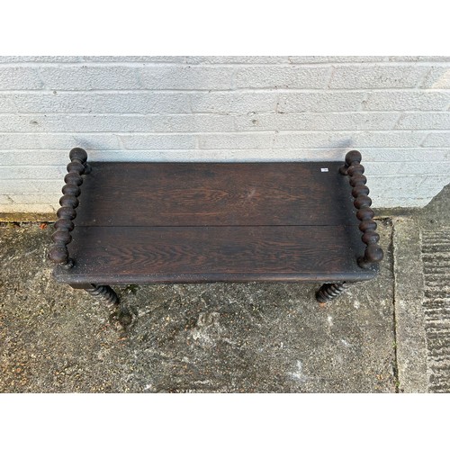 413 - A carved oak window seat/bench, with bobbin turned supports and legs -