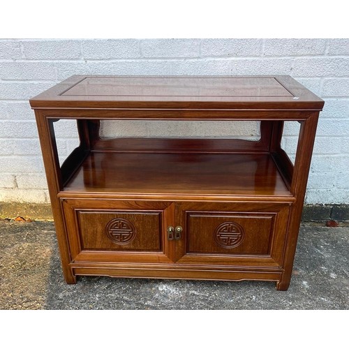 435 - A Chinese hardwood TV stand with open shelf over two cupboard doors -