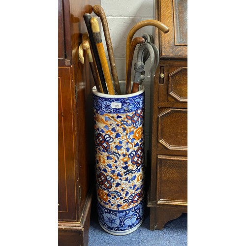 399 - An Imari decorated stick stand and a quantity of walking sticks -