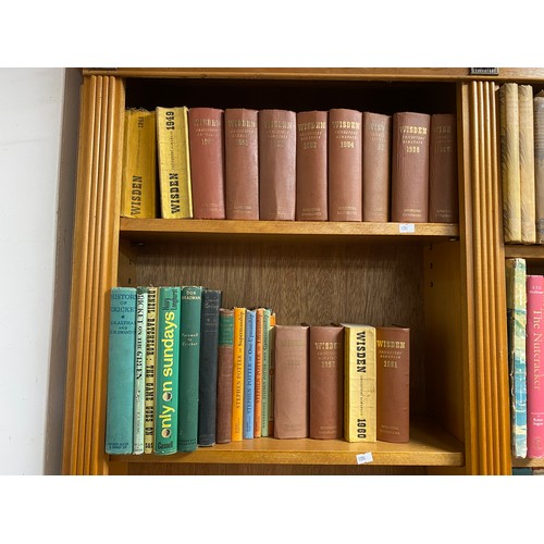 142 - Two shelves of books of cricketing interest, including a run of Wisden 1948 -1961 -