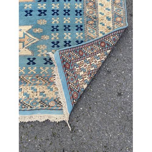 281 - A blue and cream ground rug, worked with geometric detail approximately 270 x 180 cm -