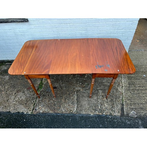 283 - A mahogany dining table, with additional leaf, on ring turned legs -