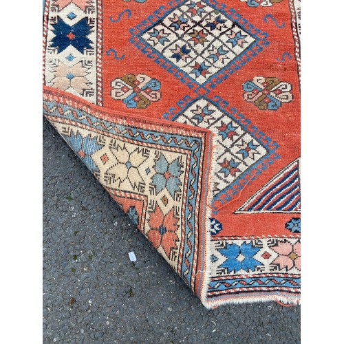 287 - A small rug, worked with details on a red and cream ground, approximately 125 x 90 cm -