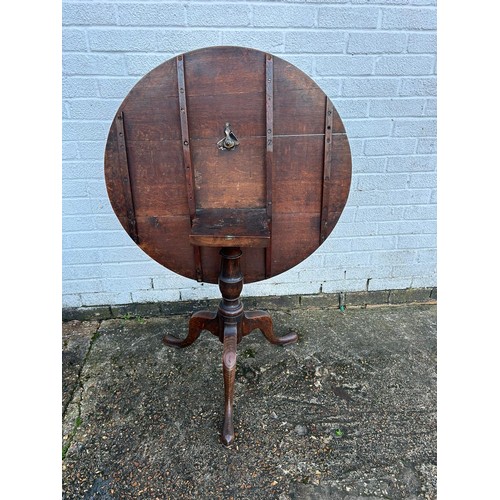 304 - A 19th Century oak tilt top table, with circular top on central support on three legs -