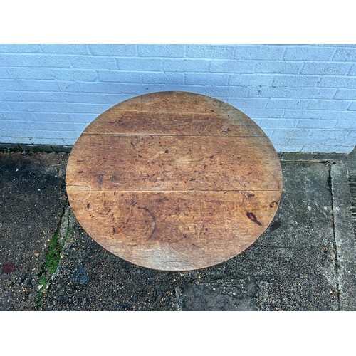 304 - A 19th Century oak tilt top table, with circular top on central support on three legs -