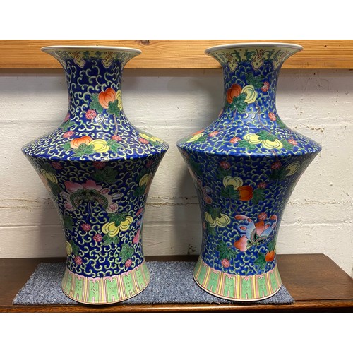 95A - A pair of Chinese vases, each enamelled with butterflies and fruit on a blue ground -