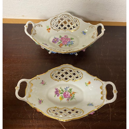 128 - A pair of Dresden bon-bon dishes each modelled with fruit and flowers, twin handles and pierced side... 