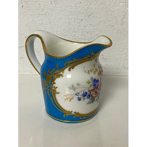 137 - A 19th Century Sevres jug, painted with a panel of flowers on a powder blue ground -