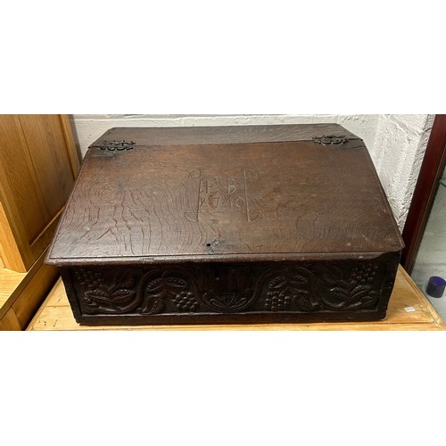 350 - An oak Bible box, with sloping front, carved with EB 1740, enclosing drawers over a carved fruiting ... 