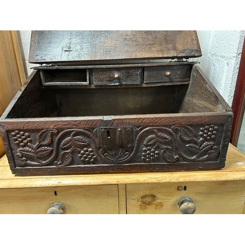 350 - An oak Bible box, with sloping front, carved with EB 1740, enclosing drawers over a carved fruiting ... 