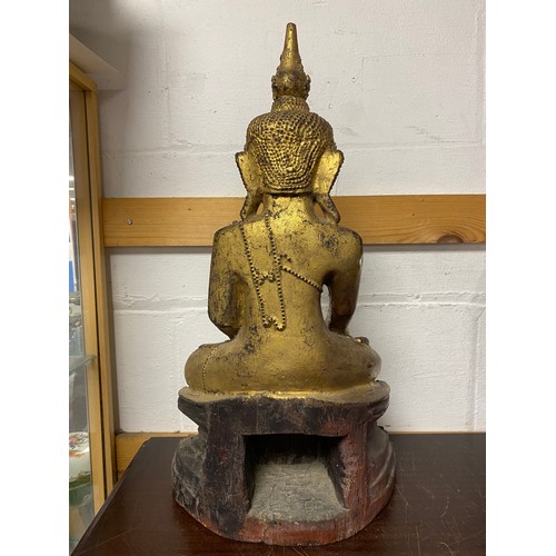 48 - A carved and gilded model of a deity, seated in repose with mirrored inlay -