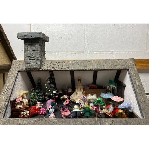 247 - A Robert Stubbs Tudor Dolls House, designed as a two storey building, with hat shop fittings and acc... 