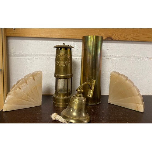 A miners lamp, together with a shell case, brass bells, etc -