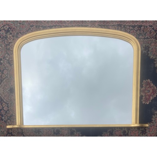 A gilt framed wall mirror, with arched top -