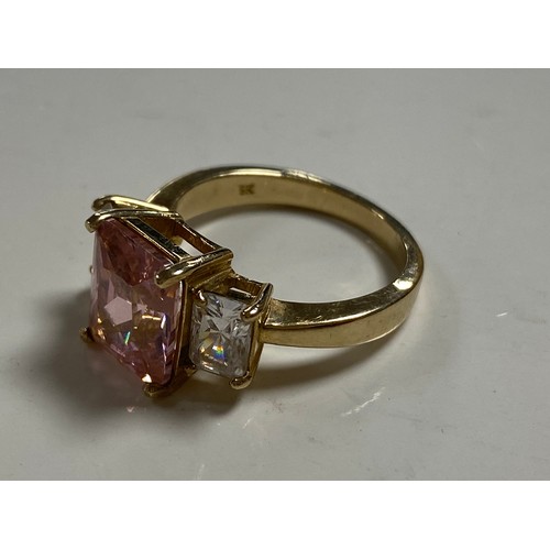 29 - A modern 9ct gold dress ring, set with a rectangular pink CZ between similarly cut clear stones, in ... 