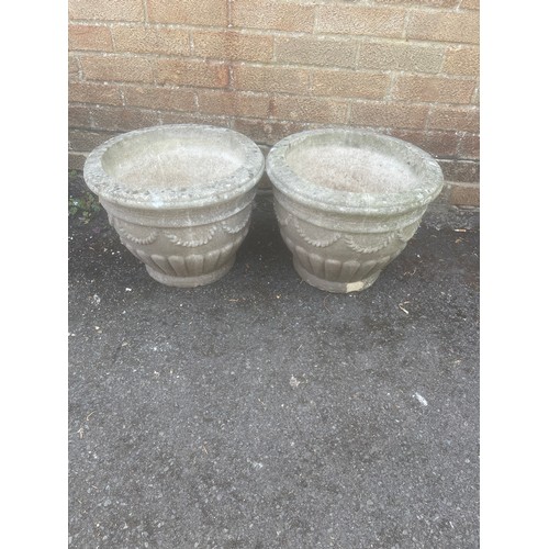 A pair of reconstituted garden planters with swag decoration -