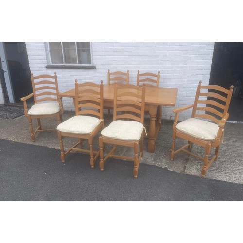 An oak refectory style dining table, on baluster supports, with a set of six ladderback chairs -