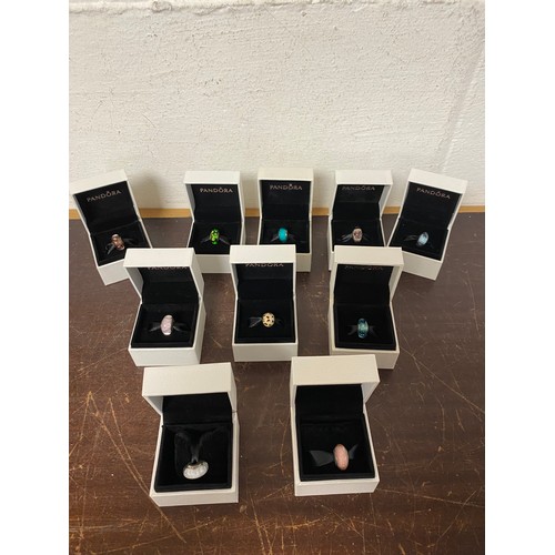 21 - A quantity of modern charms, stamped Pandora and five wristwatches -
