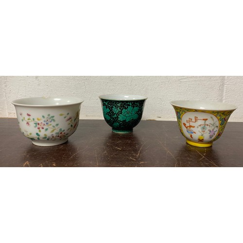 Three Chinese porcelain tea bowls, comprising one enamelled on a yellow ground, one in turquoise and  black and one with flowers (3) -