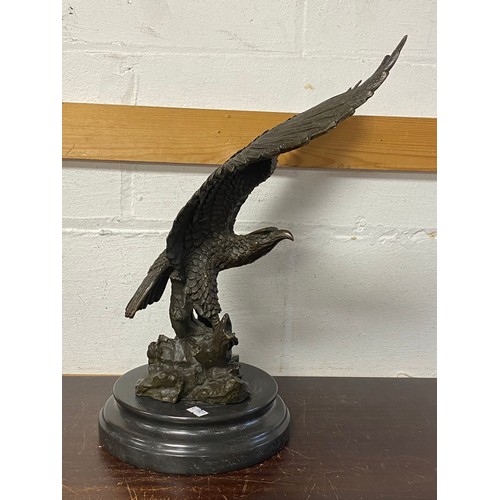 182 - A bronze model of an eagle, with wings outstretched, on circular base -