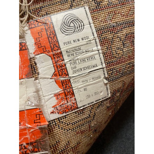 395 - An eastern wool rug, worked with central motif on a red ground within cream and red guard stripes, a... 