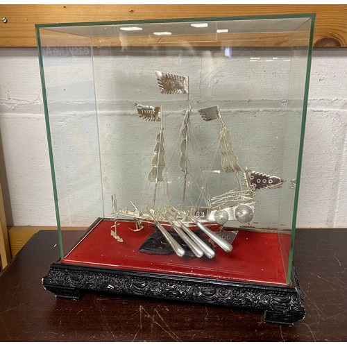 31 - A white metal model of a sailing junk, in case -