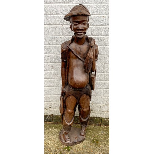 171 - A large Indonesian carved hardwood figure, naturalistically carved as a standing fisherman -