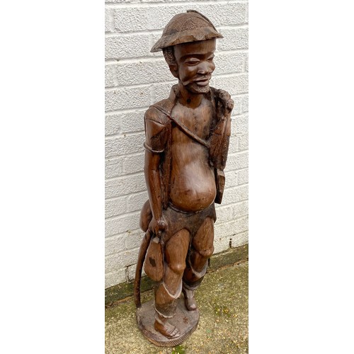 171 - A large Indonesian carved hardwood figure, naturalistically carved as a standing fisherman -