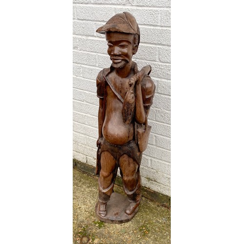 171 - A large Indonesian carved hardwood figure, naturalistically carved as a standing fisherman -