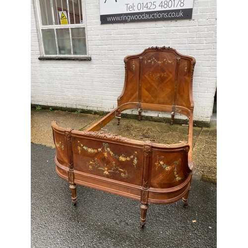 A French carved and painted bedframe, carved with flowers and leaves, painted to rear foot with swags and flowers -