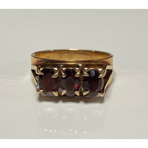 106 - A 9ct gold ring, set to the front with three oval garnets -