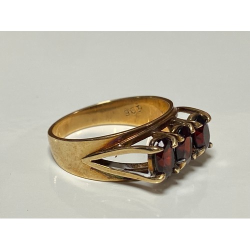 106 - A 9ct gold ring, set to the front with three oval garnets -