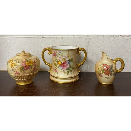 240 - A large Royal Worcester two handled loving cup, painted with flowers on a blush ground, with gilded ... 