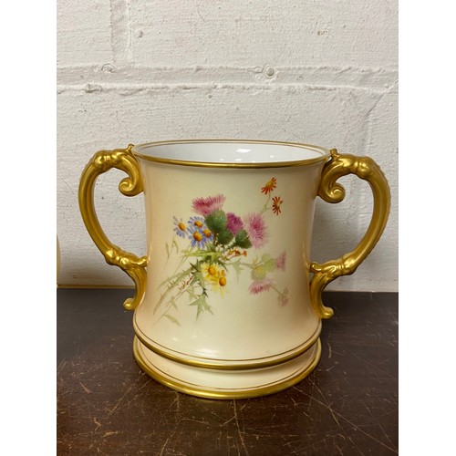 240 - A large Royal Worcester two handled loving cup, painted with flowers on a blush ground, with gilded ... 
