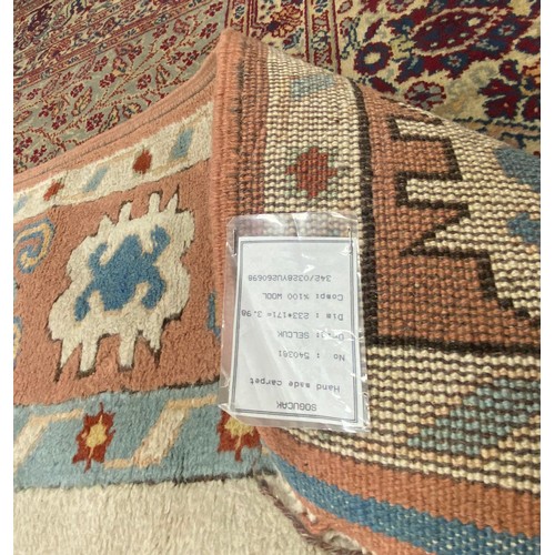 439 - A large Turkish wool carpet, worked in peach and cream approximately, 230 x 170 cm -