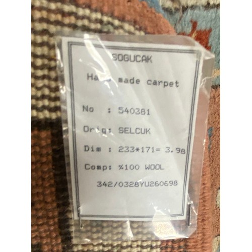 439 - A large Turkish wool carpet, worked in peach and cream approximately, 230 x 170 cm -