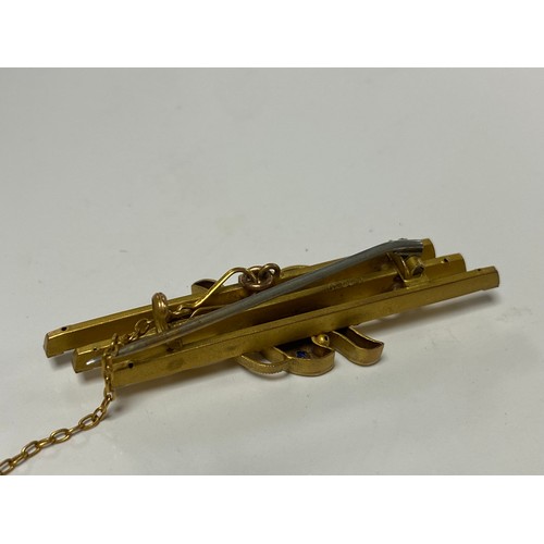 140 - An early 20th Century 9ct gold bar brooch, set with sapphires and a diamond point -