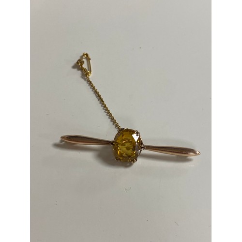126 - A citrine set bar brooch, the oval citrine claw set to yellow metal bar -
