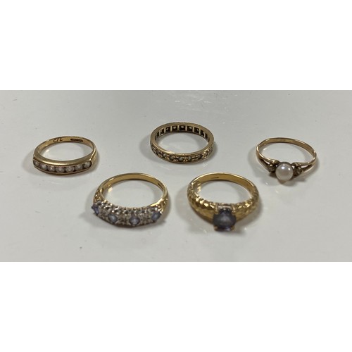 130 - A 9ct gold ring set with a circular blue stone and four other 9 ct gold rings -