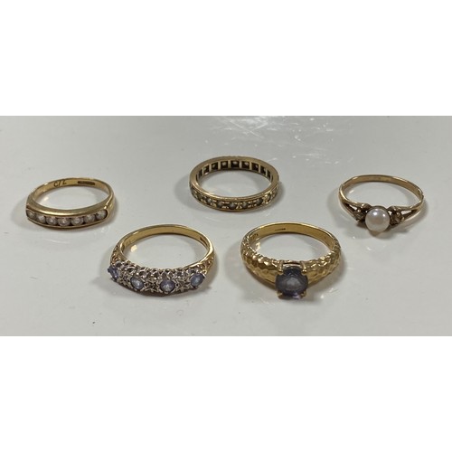 130 - A 9ct gold ring set with a circular blue stone and four other 9 ct gold rings -