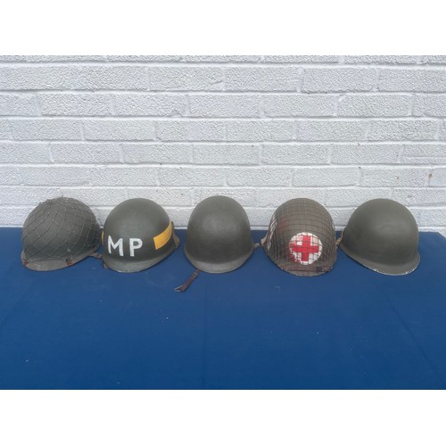 A group of five military helmets, to include US MP, medic and infantry ...