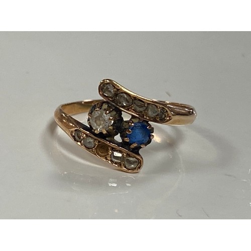 40 - A sapphire and diamond ring, of crossover design, set in yellow metal mount -