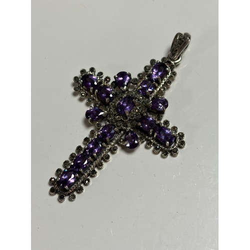 18 - A silver cross pendant, stamped 925, set with amethysts -